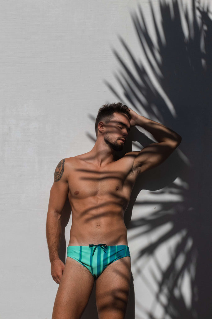 Feel confident and stylish with Smithers' newest addition: a striped green swimsuit expertly worn by a fit and attractive young man.