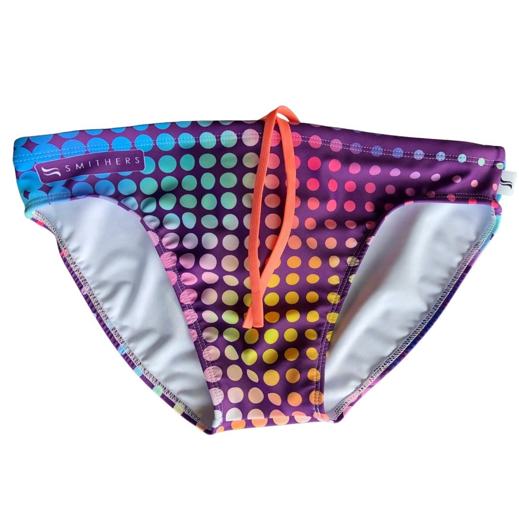 Fever is the 2023 disco inspired swimsuit for World Pride. The swimsuit has a purple base with a polka dot pattern that is layered with rainbow gradient. The drawstring is a peach orange colour and the Smithers logo sits proudly on the upper right corner on front of the swimsuit